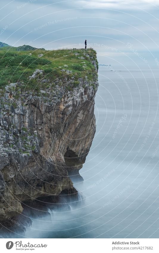 Person steht auf einer Klippe über dem Meer MEER felsig Saum Silhouette Felsen wolkig Ufer Freiheit Asturien Spanien Ribadesella-Küste Himmel Seeküste Reisender