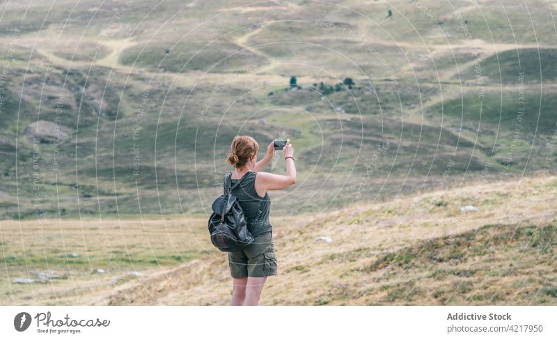 Unbekannter Wanderer, der die Landschaft mit seinem Smartphone fotografiert fotografieren Natur Hügel erkunden Fernweh Frau benutzend Apparatur Gerät Rucksack