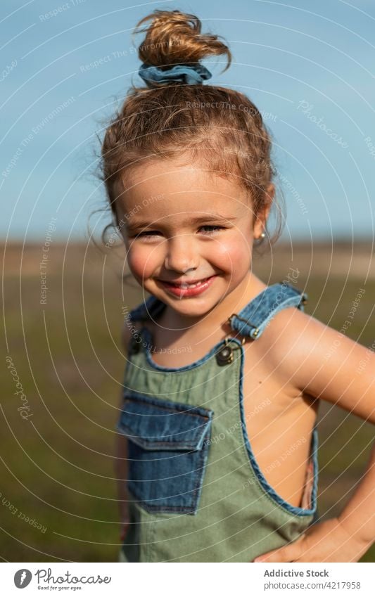Lächelndes kleines Mädchen auf einem Feld im Sommer gesamt Stil niedlich wenig Outfit heiter sonnig Glück Kindheit Optimist Freude Wiese sorgenfrei froh stehen