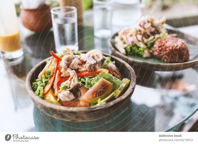Appetitlicher Hühner- und Gemüsesalat auf einem Glastisch serviert Salatbeilage Speise lecker Mahlzeit geschmackvoll Amuse-Gueule Mittagessen Küche