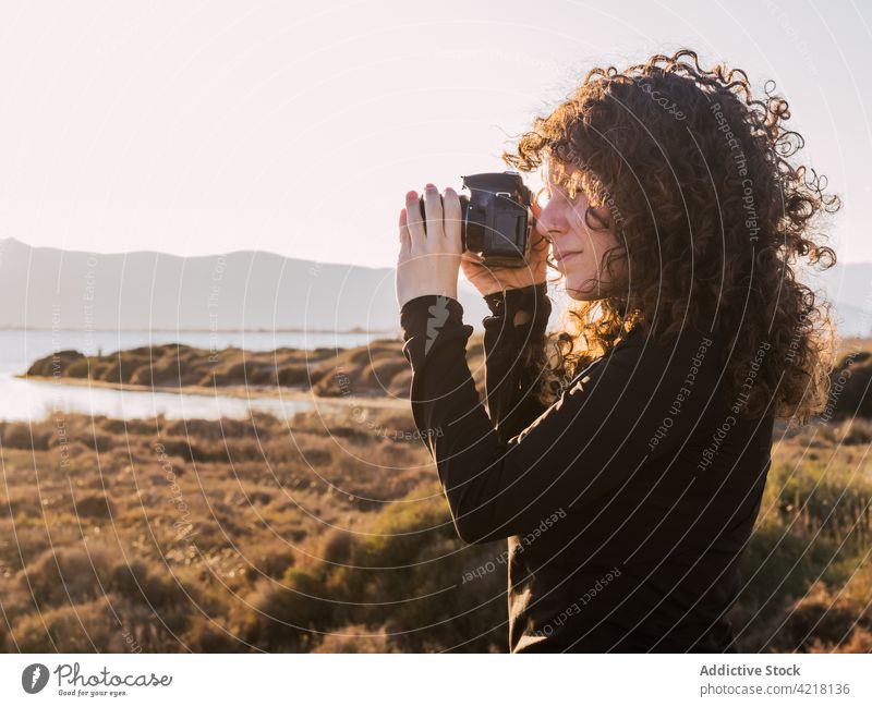 Frau mit Fotoapparat am Strand MEER Reisender Fotografie Natur nehmen ethnisch Urlaub Fokus reisen Glück Tourist Feiertag positiv genießen fotografieren