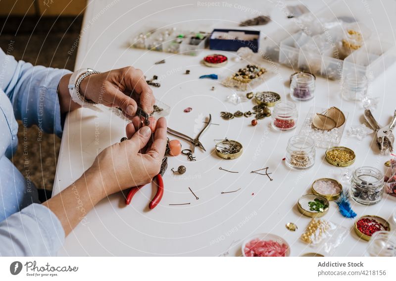 Frau macht Accessoire mit Natursteinen Kunstgewerbler Halskette Fähigkeit Instrument Werkstatt dekorieren schmücken kreieren Prozess Designer Bijouterie Zange