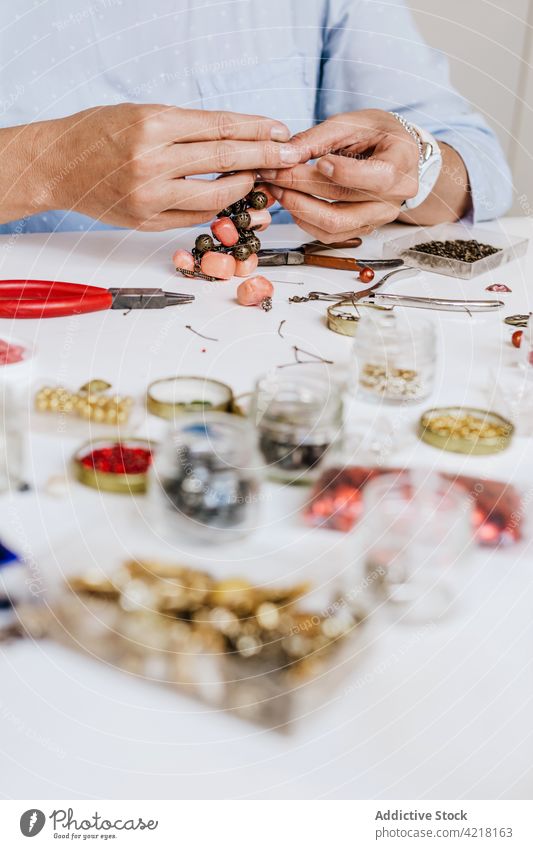 Frau macht Accessoire mit Natursteinen Kunstgewerbler Halskette Fähigkeit Instrument Werkstatt dekorieren schmücken kreieren Prozess Designer Bijouterie Zange