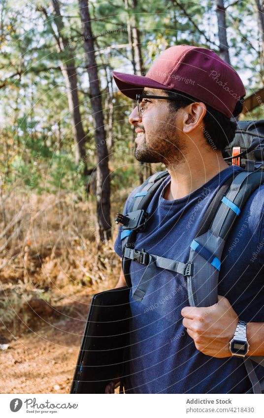 Wanderer mit Rucksack geht durch grüne Bäume im Wald Mann Nomade Backpacker Trekking Abenteuer erkunden entdecken Wanderung reisen Natur männlich Tourist Baum