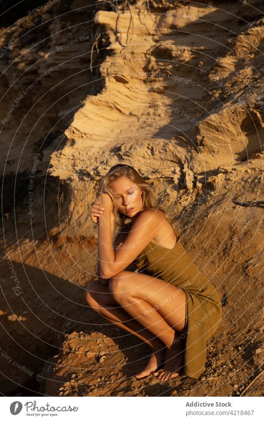 Junge Frau sitzt abends auf sandigem Boden Natur Sand Berghang friedlich Körperhaltung sorgenfrei Harmonie natürlich ruhig Gelassenheit blond vegetieren