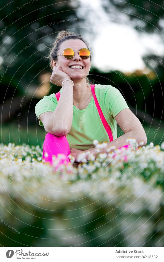 Glückliche Frau auf üppiger Wiese sitzend Freude charismatisch sorgenfrei Landschaft Waldwiese Natur Outfit Zahnfarbenes Lächeln expressiv Spaß hell heiter froh