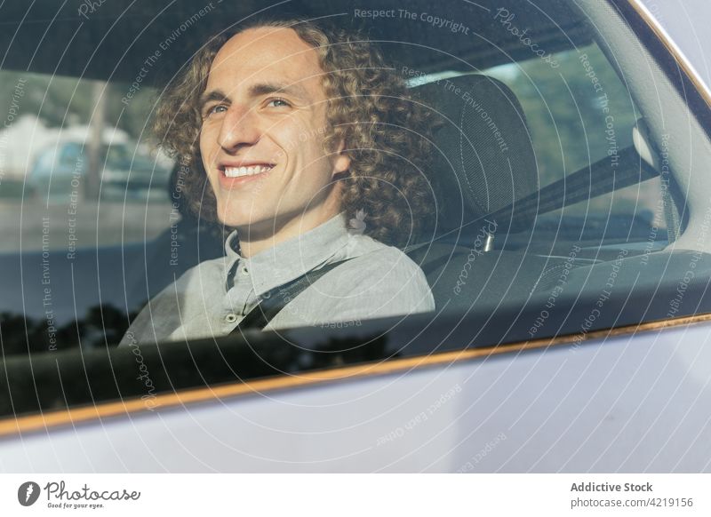 Glücklicher Mann genießt die Fahrt auf dem Rücksitz eines Autos PKW Passagier Lächeln Sicherheit Ausflug Fenster Verkehr Automobil männlich Fahrzeug Gurt jung