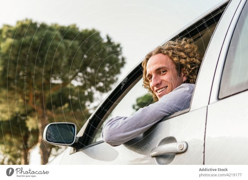 Glücklicher Mann im Auto schaut in die Kamera PKW Laufwerk Hand Natur Ausflug Lächeln genießen Fenster Freiheit Sommer reisen Fahrer männlich jung heiter Reise