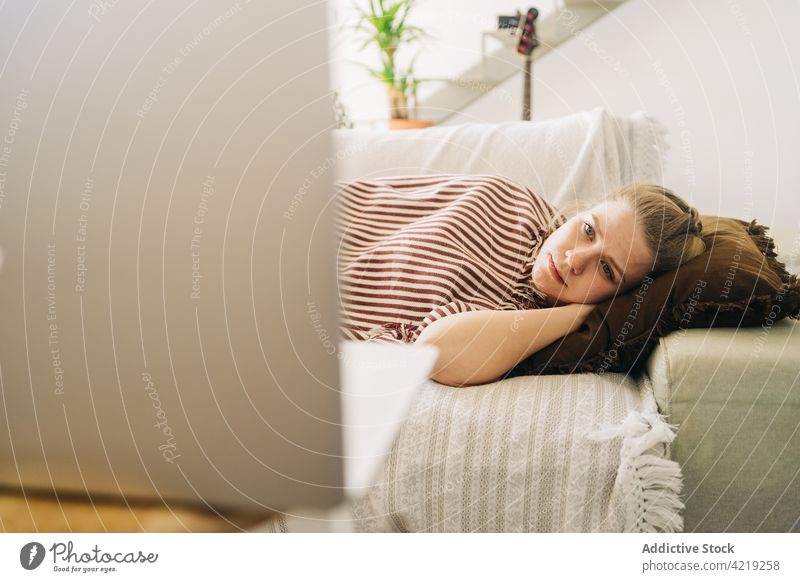 Müde Frau, die sich auf dem Sofa ausruht und einen Film auf dem Laptop ansieht zuschauend Wochenende freie Zeit müde ruhen benutzend Apparatur Gerät heimwärts