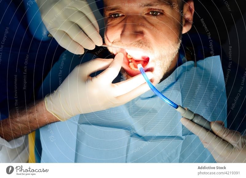 Zahnärztin mit Assistentin bei der Untersuchung der Zähne eines Patienten in der Klinik Kieferorthopäde geduldig prüfen mündlich Zahnmedizin Stomatologie Männer