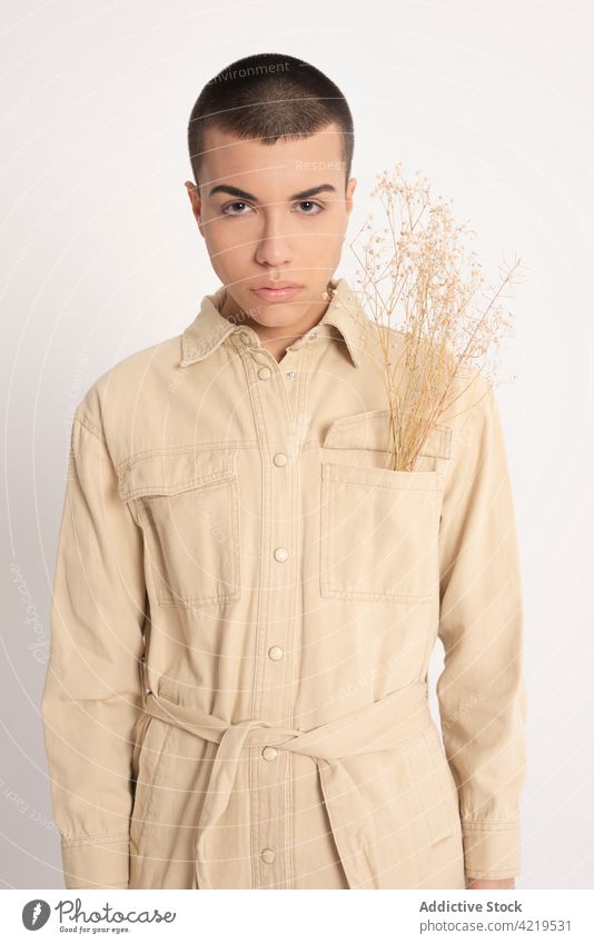 Stilvoller Mann mit getrockneten Pflanzen im Atelier androgyn Model feminin Haufen männlich Vorschein Individualität trendy Outfit Persönlichkeit Angebot