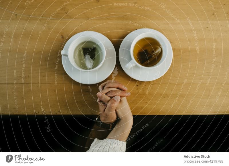 Verliebtes Paar hält Hände im Café Händchenhalten Tee Tisch Liebe Partnerschaft Zusammensein trinken romantisch Getränk sitzen Termin & Datum Becher Tasse heiß