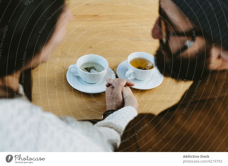 Verliebtes Paar hält Hände im Café Händchenhalten Tee Tisch Liebe Partnerschaft Zusammensein trinken romantisch Getränk sitzen Termin & Datum Becher Tasse heiß