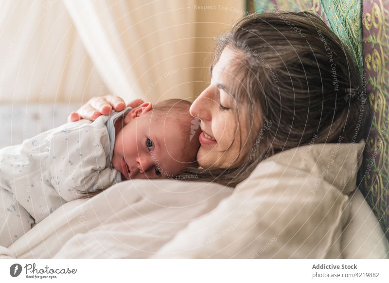 Mutter kuschelt mit neugeborenem Baby im Bett Mama Umarmen Säuglingsalter Mutterschaft Harmonie Frau Mittagsschlaf Gelassenheit Haus Elternschaft Zusammensein