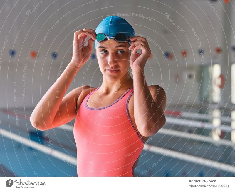 Sportlerin in Badeanzug und Schwimmbrille am Schwimmbad Schwimmer achtsam Schutzbrille Badebekleidung Wellness Vitalität Pool Frau Porträt Körper Schwimmsport