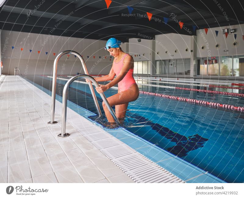 Schwimmer im Schwimmbad mit Bahnen vor dem Training Pool Sport Schwimmsport Wellness Vitalität passen Frau Schutzbrille Badebekleidung Körper Geländer