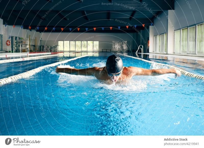 Sportler mit Schwimmbrille beim Schwimmen im Pool während des Trainings Schwimmer schwimmen Schmetterlingsstil schnell stark Mann Bewegung Motivation Kraft