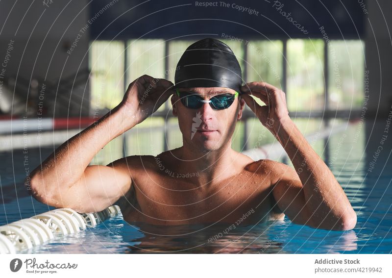 Schwimmer mit Schwimmbrille beim Training im Schwimmbad Sport muskulös maskulin nackter Torso Pool Mann Porträt üben Körper Wellness passen professionell Wasser