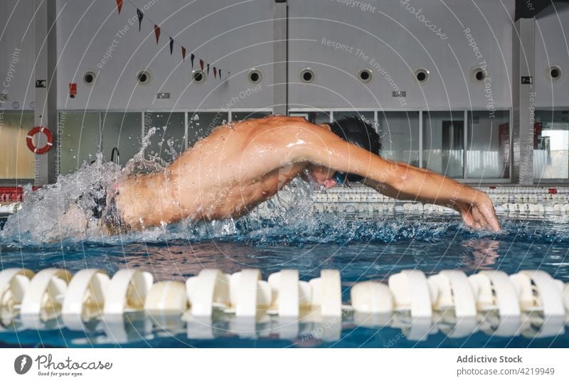 Sportler mit Schwimmbrille beim Schwimmen im Pool während des Trainings Schwimmer schwimmen Schmetterlingsstil schnell stark Mann Bewegung Motivation Kraft