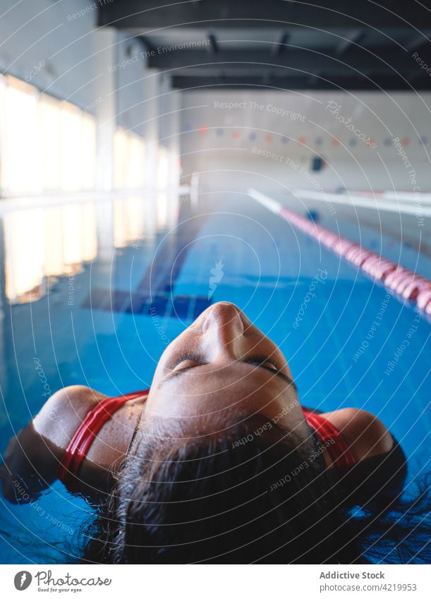 Sportlerin im Badeanzug schwimmt im Pool mit transparentem Wasser schwimmen Wellness Vitalität Energie feminin Bewegung Frau Rippeln Badebekleidung Athlet rein