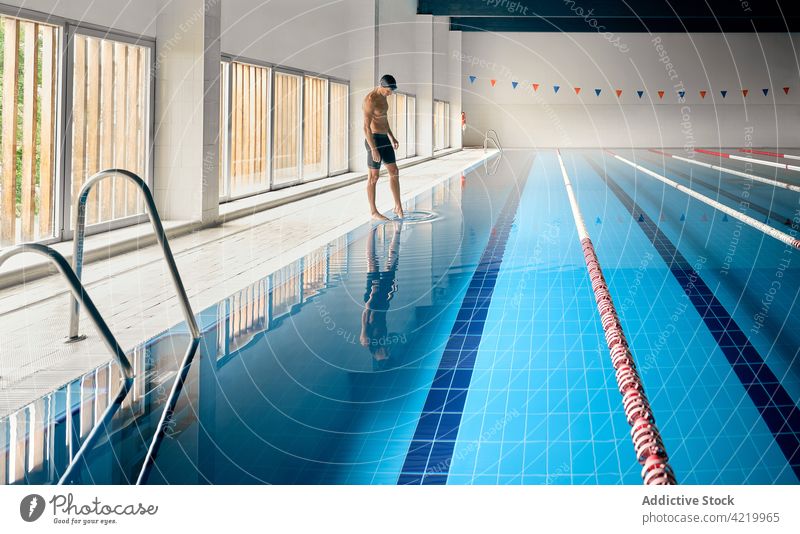 Schwimmer, der das Wasser berührt, während er sich im Becken spiegelt Reflexion & Spiegelung Pool Sport Training professionell Wellness Fahrspur Mann