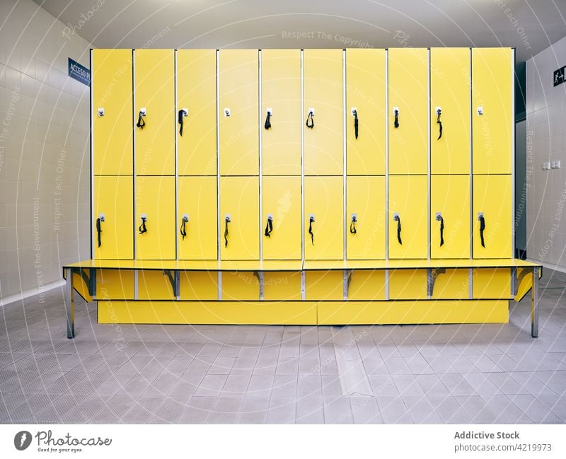 Leere Umkleidekabine mit gelber Bank und gefliestem Boden Spind Raum modern Stil Innenbereich kreativ Design Gang leer Einsamkeit Flur gekachelt Stock Farbe
