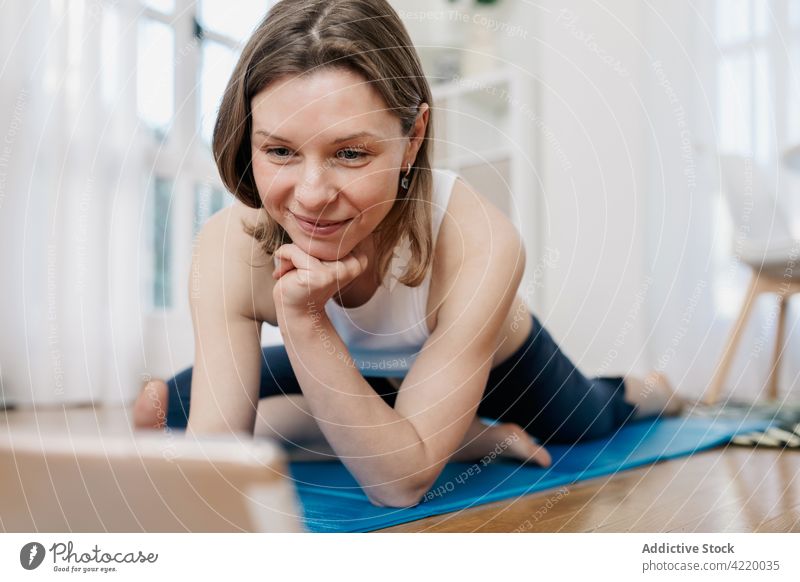 Lächelnde Frau wählt Video-Tutorial für Yoga zu Hause Tablette Lektion wählen heimwärts vorbereiten Browsen pflücken Internet Gerät Apparatur benutzend Lügen