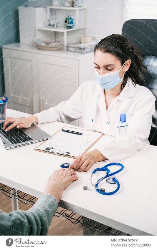 Arzt misst den Puls eines nicht erkennbaren Patienten mit einem Oximeter in der Klinik arzt messen geduldig Laptop Gesundheitswesen Frau benutzend Apparatur