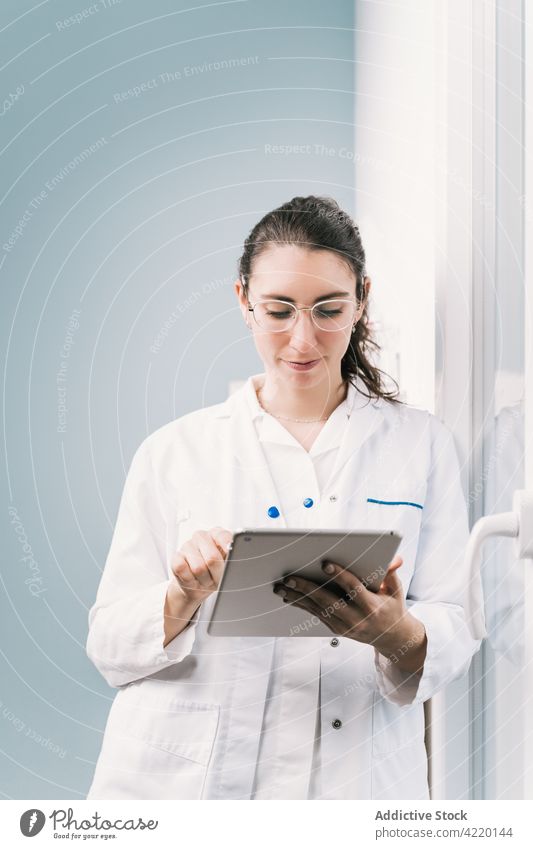 Krankenschwester in Uniform bei der Arbeit am Tablet im Krankenhaus Krankenpfleger Tablette professionell Internet online Frau Reflexion & Spiegelung Klinik