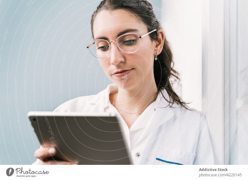 Krankenschwester in Uniform bei der Arbeit am Tablet im Krankenhaus Krankenpfleger Tablette professionell Internet online Frau Reflexion & Spiegelung Klinik
