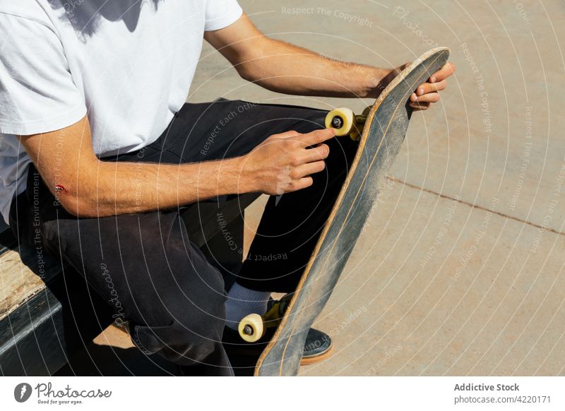 Männerhände mit einer Schramme, die ein Skateboard halten jung Mann Schlittschuhlaufen unkenntlich Rad Skatepark Skater Holzplatte Sport Beton gelb Stil