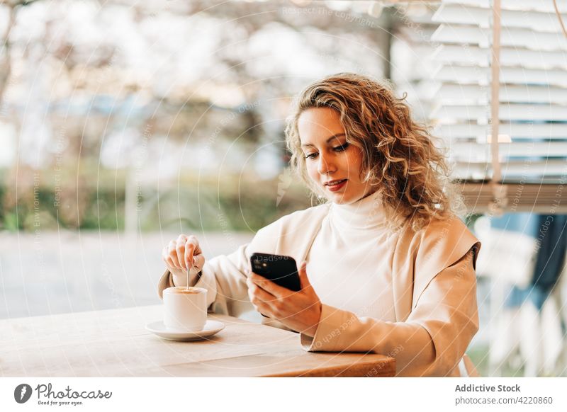 Frau benutzt Mobiltelefon in einem Café Smartphone Kaffee Kaffeehaus trinken Getränk Browsen Tasse soziale Netzwerke Nachricht Heißgetränk benutzend Mobile