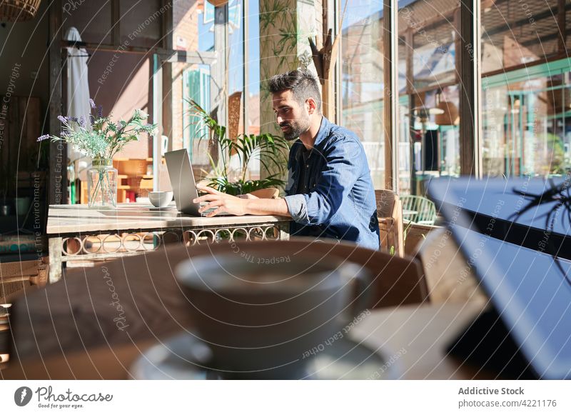 Ethnischer Freiberufler arbeitet am Laptop am Restauranttisch Arbeiter Tippen freiberuflich Inbetriebnahme Projekt unabhängig Mann benutzend Apparatur Gerät