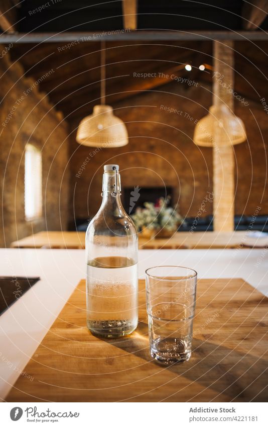 Glas und Flasche Wasser auf dem Schneidebrett zu Hause frisch rein natürlich durchsichtig Küche hölzern Tisch heimwärts Material organisch liquide