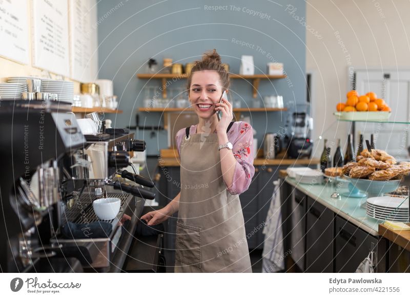 Junge Frau arbeitet in einem Café Menschen junger Erwachsener lässig attraktiv Lächeln Glück im Innenbereich Kaukasier zahnfarben genießend Restaurant Schürze