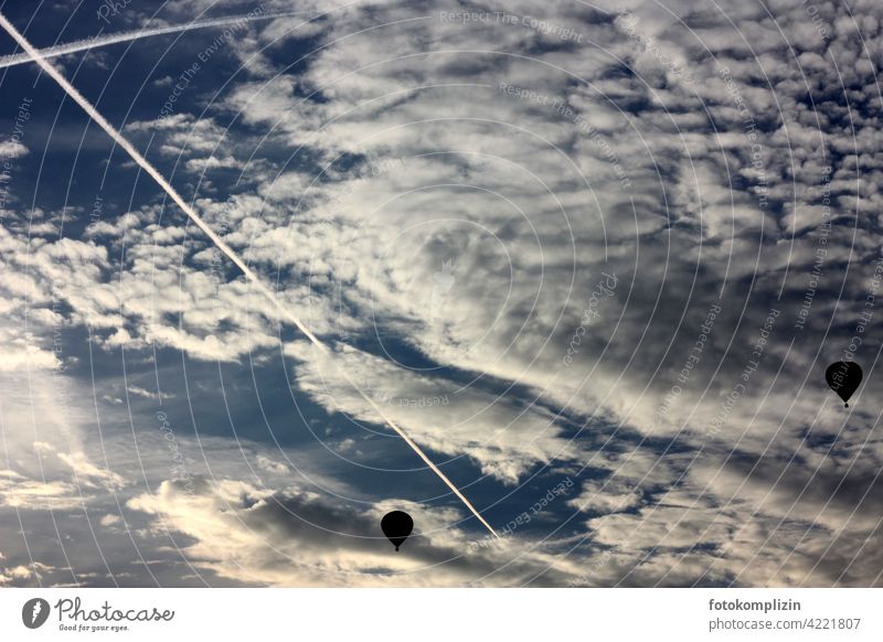 zwei Heißluftballons am bewölkten Himmel Heißluftballonfahrt Kondensstreifen Wolken fliegen Luftverkehr Freiheit Ferne Fernweh fliegend Flug Luftraum