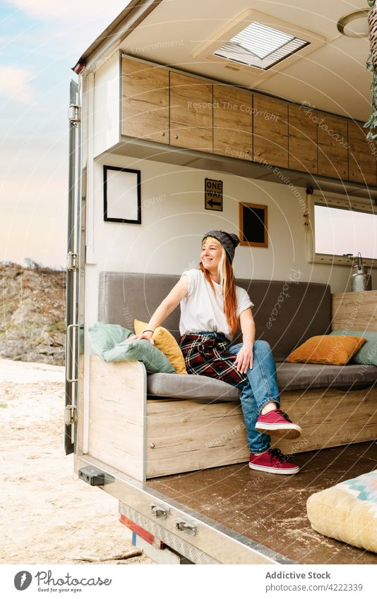 Zufriedene Frau entspannt sich auf dem Sofa im Van reisen Kleintransporter Reisender Lastwagen See Hipster Urlaub genießen sitzen ruhen Feiertag Sommer Ausflug