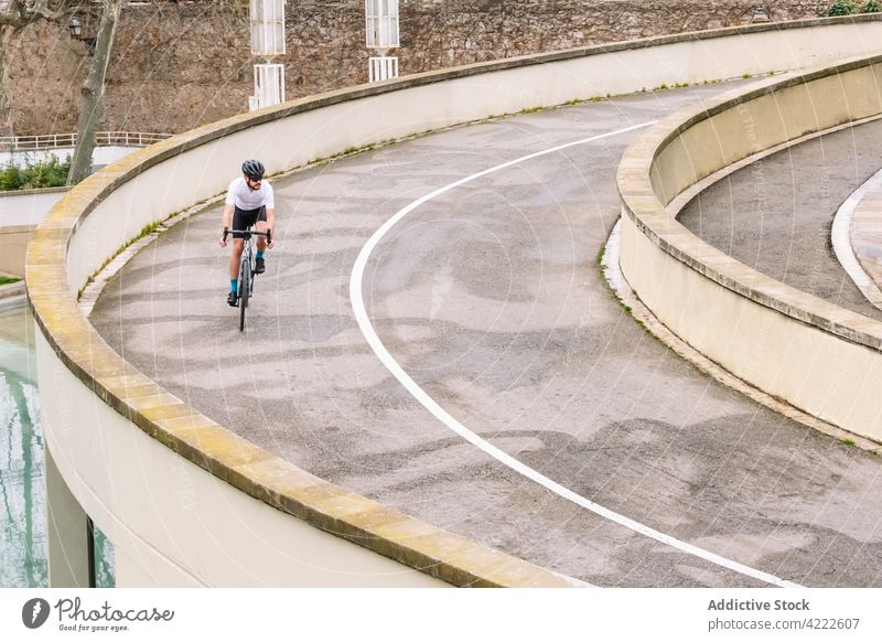 Radfahrer auf welliger Straße in der Stadt Mitfahrgelegenheit Fahrrad Sport Fahrradfahren Training üben Mann Biker Verkehr Fahrbahn Asphalt gekrümmt Fahrzeug