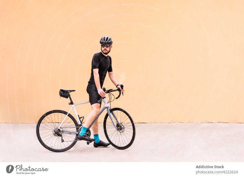 Radfahrer mit Fahrrad auf städtischem Bürgersteig Sport professionell Stil maskulin Spaziergang Straßenbelag urban Mann Verkehr Fahrzeug Kniestrümpfe Schutzhelm