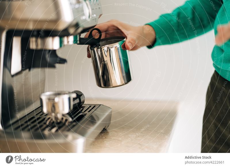 Crop Person mit Krug gegen Kaffeemaschine zu Hause Heißgetränk vorbereiten professionell Stil modern heimwärts Prozess Metall Material Zeitgenosse kreativ