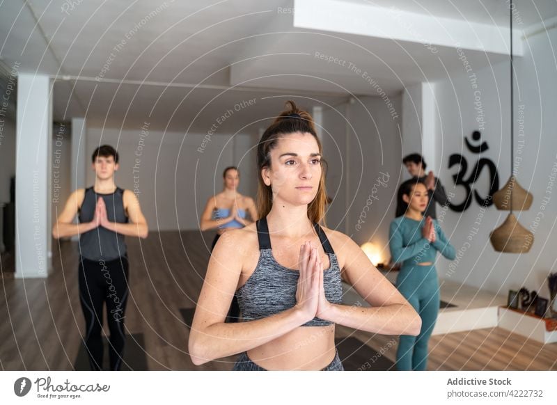 Frau übt Yoga während einer Gruppenstunde im Studio Klasse Lektion üben Menschen Zusammensein Berg-Pose Menschengruppe Wellness Asana Windstille Zen Energie