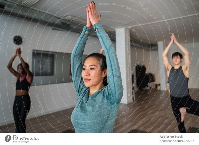 Frau übt Yoga während einer Gruppenstunde im Studio Klasse Lektion üben Menschen Zusammensein Berg-Pose Menschengruppe Wellness Asana Windstille Zen ausdehnen