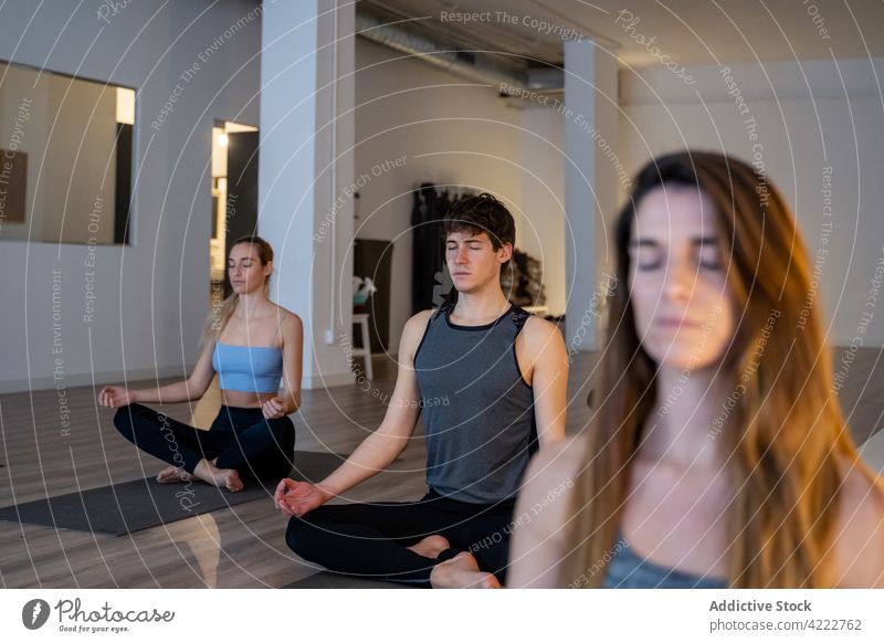 Friedliche multiethnische Menschen meditieren gemeinsam während einer Yogastunde Klasse Lektion Zusammensein Achtsamkeit Zen Lotus-Pose Atelier