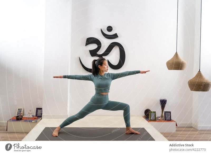 Asiatische Frau macht Yoga in Kriegerpose im Studio Krieger-Pose Atelier üben Anmut schlank beweglich Gleichgewicht Achtsamkeit asiatisch ethnisch Asana