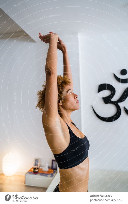 Ethnische Frau macht Yoga in Bergpose im Studio Berg-Pose üben Dehnung ruhig Asana Atelier friedlich ethnisch Windstille Afro-Look Frisur urdhva hastasana