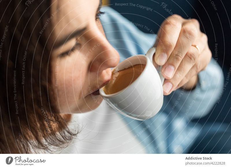 Frau trinkt Kaffee aus einer kleinen Tasse zu Hause Espresso trinken Aroma Getränk brauen genießen schwanger Schwangerschaft Harmonie Windstille Angebot