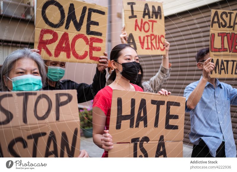 Asiatische Demonstranten mit Gesichtsmasken und Plakaten auf den Straßen der Stadt Protestierender Stoppt den Asiatenhass Ich bin kein Virus eine Rasse