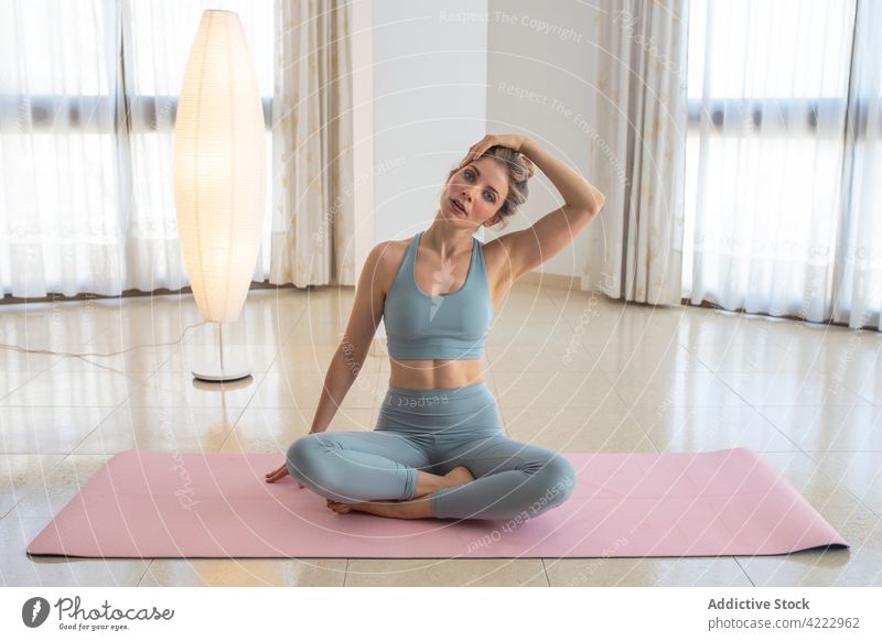 Gelassene Frau, die ihren Körper vor der Yoga-Praxis zu Hause aufwärmt Dehnung Hals Aufwärmen heimwärts beweglich üben ruhig sich[Akk] entspannen Gesundheit