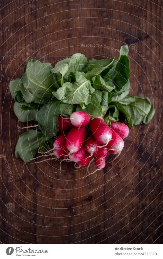 Stapel frischer Radieschen mit gewelltem Laub auf Holzoberfläche Rettich Gemüse gesunde Ernährung Nährstoff Vitamin Produkt organisch Laubwerk Haufen rustikal