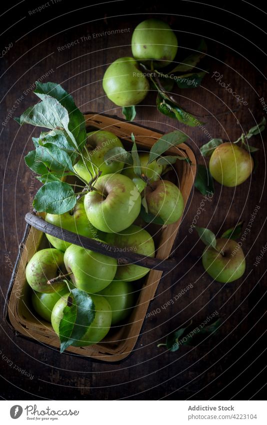 Frische Äpfel mit Laub im Korb auf braunem Hintergrund Apfel Frucht gesunde Ernährung natürlich reif frisch organisch Blatt Haufen Handgriff Ernte Bestandteil